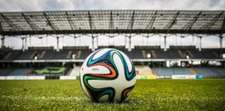 Up close of a soccer ball on the grass of a stadium