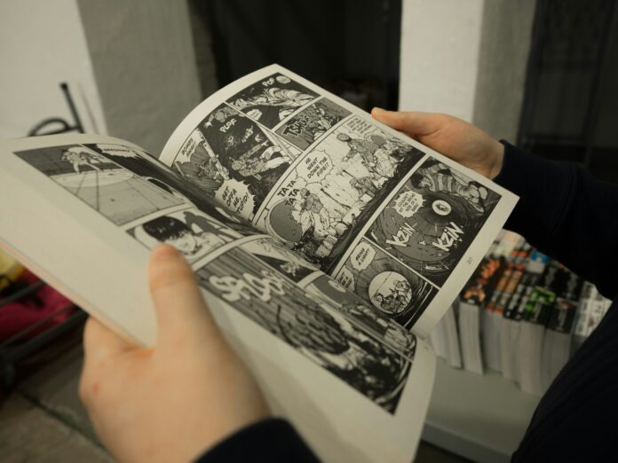 A person clutches a comic book, featuring eye-catching graphics.