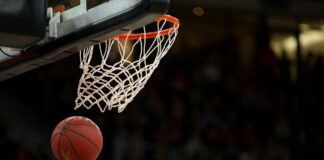 A basketball swishing through a basketball hoop.