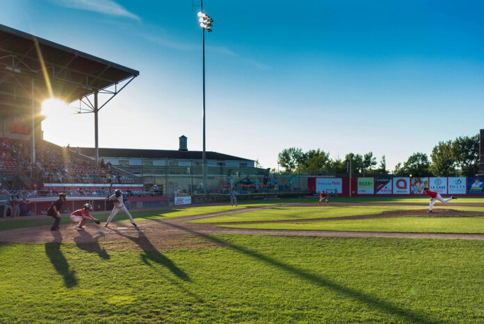Players playing Baseball in a Ballpark.