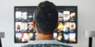 How AI is Used to Both Enable and Combat Illegal Streaming Person browsing movies and TV shows on a streaming service using a smart TV.