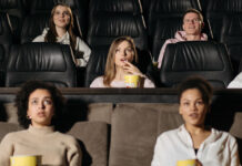 We Ran the IMDB Top 250 Through the Bechdel Test. 95 Pass, 155 Fail Moviegoers watching a film in a theater, representing popular and top-rated movies.