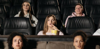 We Ran the IMDB Top 250 Through the Bechdel Test. 95 Pass, 155 Fail Moviegoers watching a film in a theater, representing popular and top-rated movies.