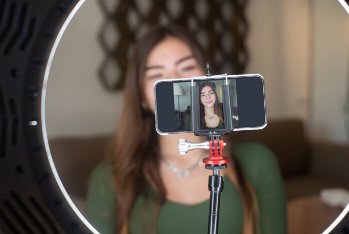 LiveStreamSafety Young happy woman live streaming on mobile device
