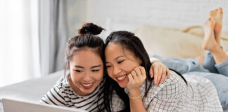 Soap2Day Is Gone — Here’s Where to Watch Those Movies & Shows Legally Two smiling women enjoying time together using a laptop in a cozy bedroom setting.